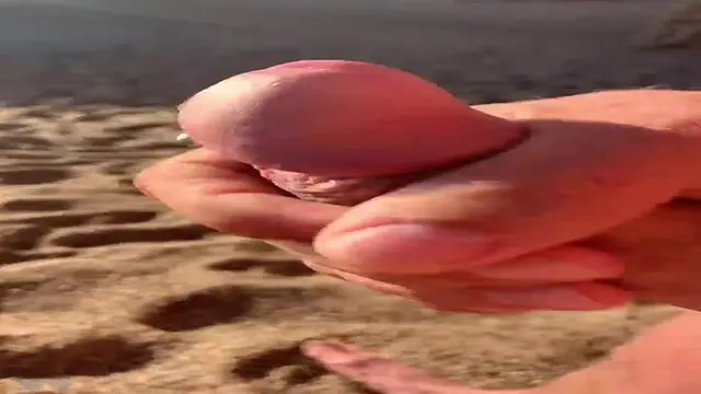 Horny guy jerks off in the open air by the beach.